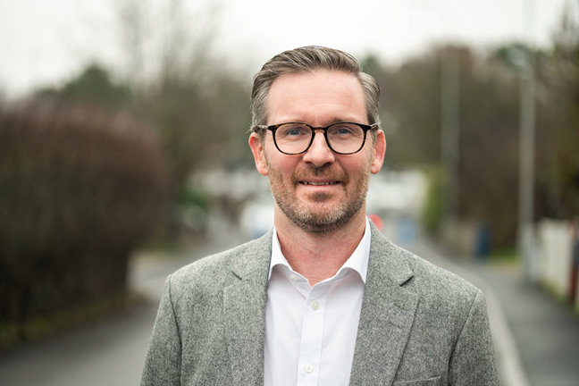 Foto på en man i vit skjorta och grå kavaj