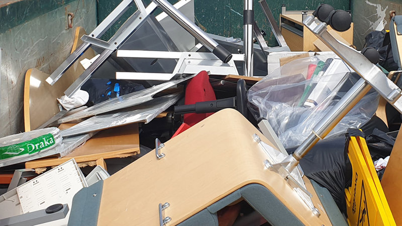 Foto som visar en container där möbler och inredning har slängts