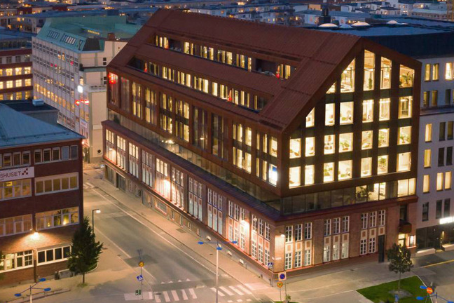 Nattvy över stadsbyggnader med belysta fönster och tomma gator.