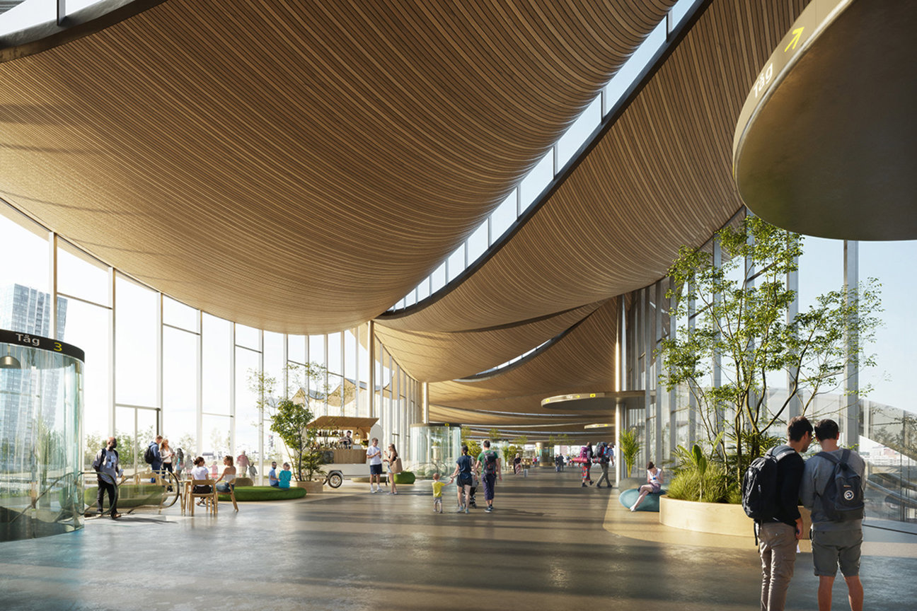 En modern hall med böjda trätak, stora fönster och flera människor. Växter och träd finns i rummet.