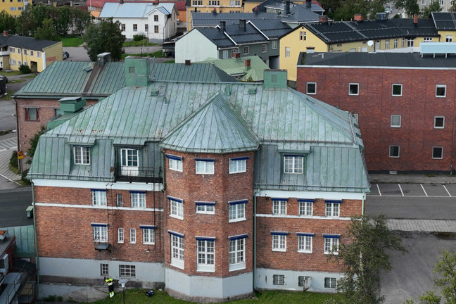 Luftbild av flera färgglada bostadshus med röda och gröna tak