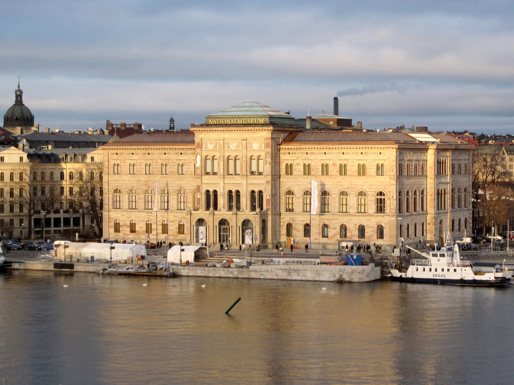 Nationalmuseum byggnad vid vatten med båt och andra byggnader i bakgrunden.