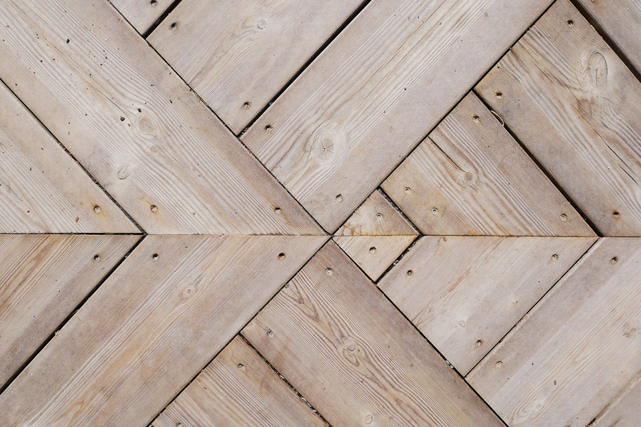 Ljusa träplankor i herringbonemönster.