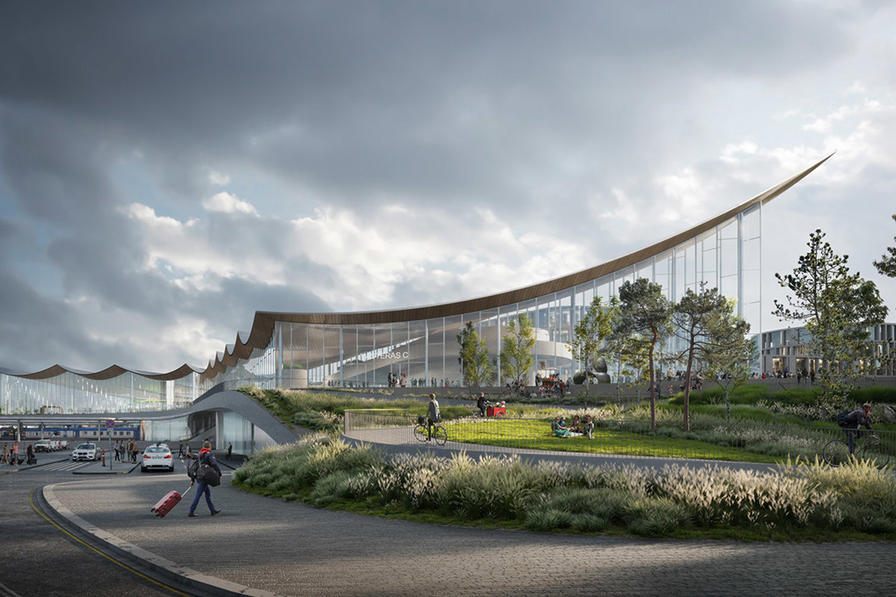 Modernt byggnadskomplex med böjd glasfasad, människor promenerar, cyklar och sitter på gräsmattan under molnig himmel.